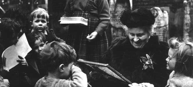 Svartvit bild föreställande Maria Montessori och två barn