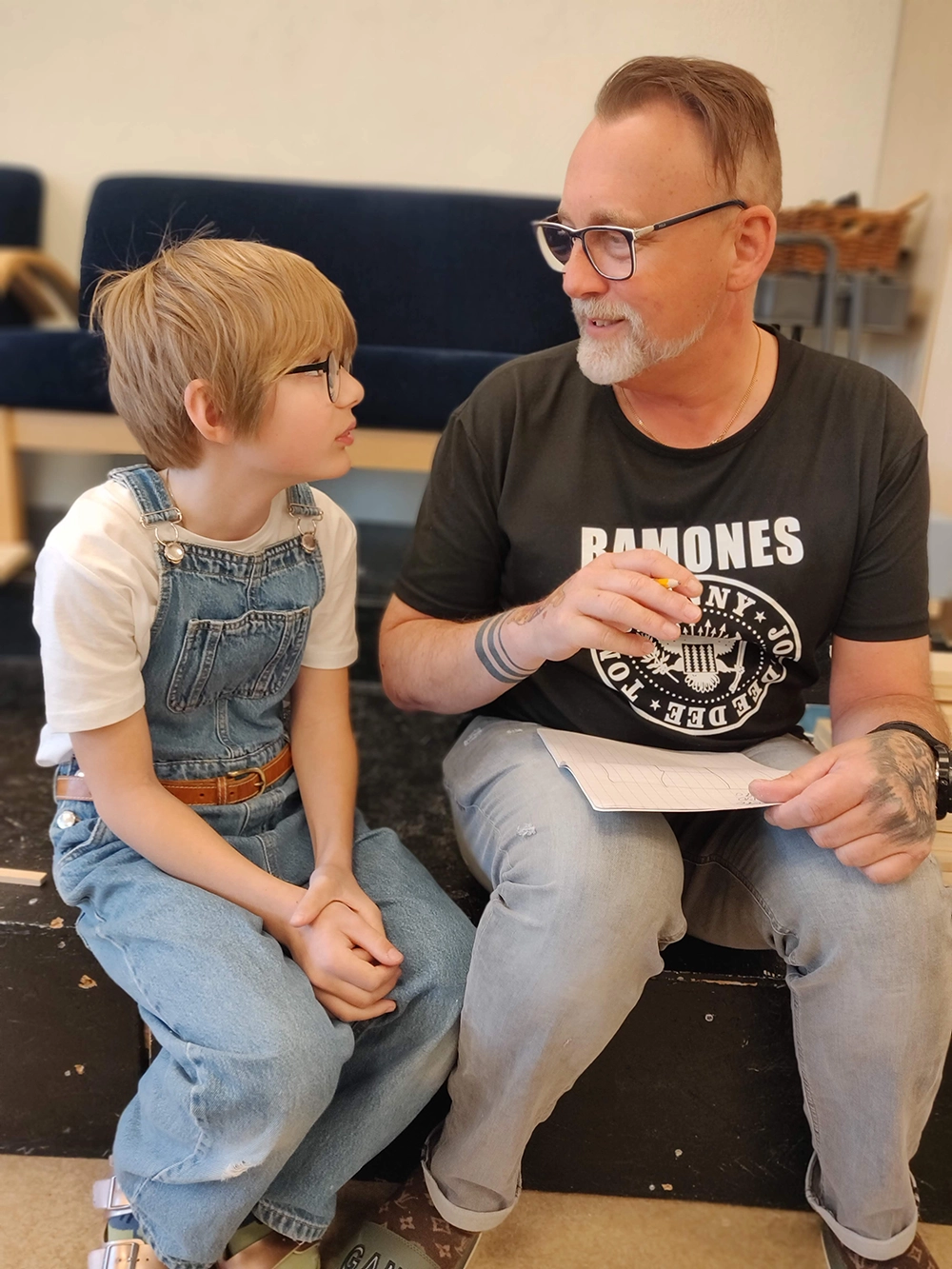Manlig lärare och pojke sitter och läser