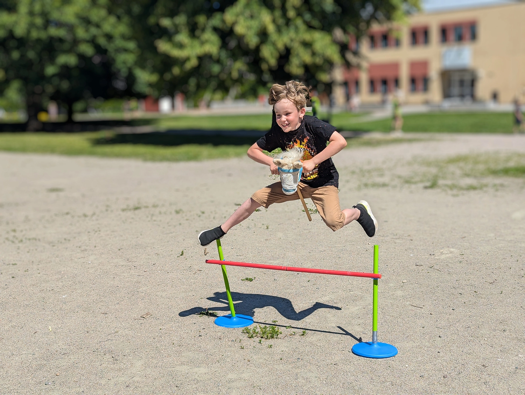 Elev hoppar med en käpphäst på skolgården